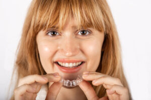 Beautiful smiling young woman with aligner.