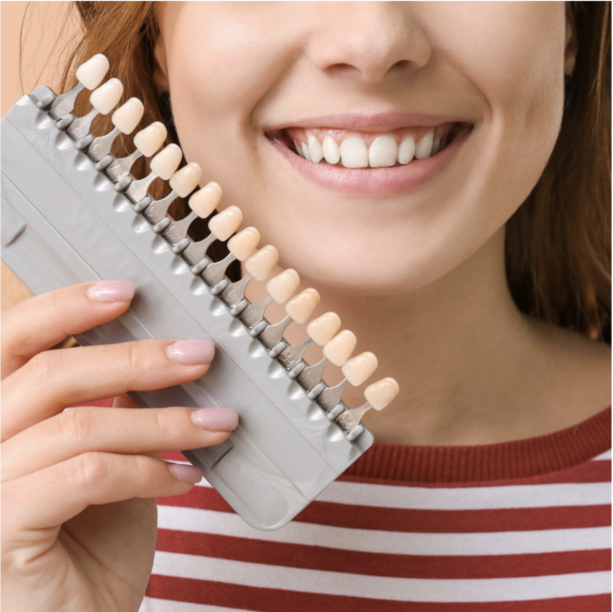 woman holding a set teeth veneers